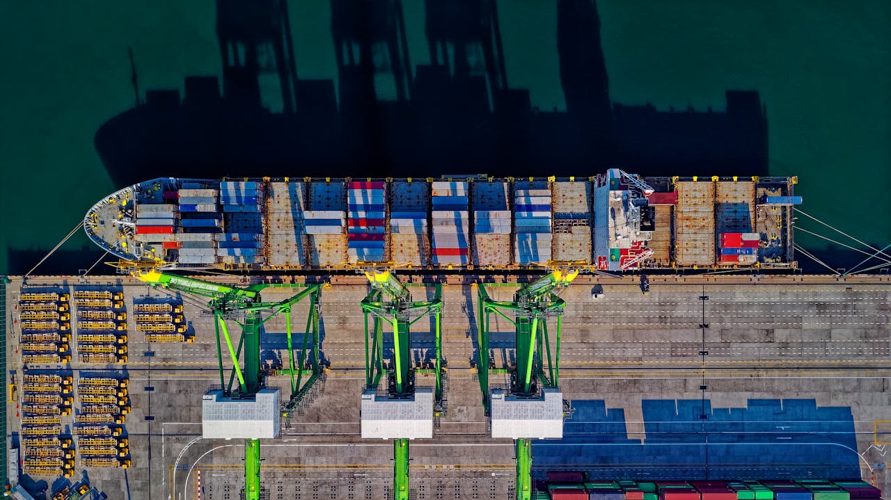 High angle aerial view of a cargo ship at a bustling port in Jakarta, showcasing global trade.